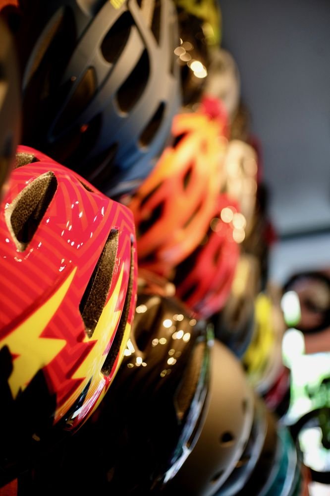 Wall of bike helmets for kids and adults at Flo On Wheels Cycles